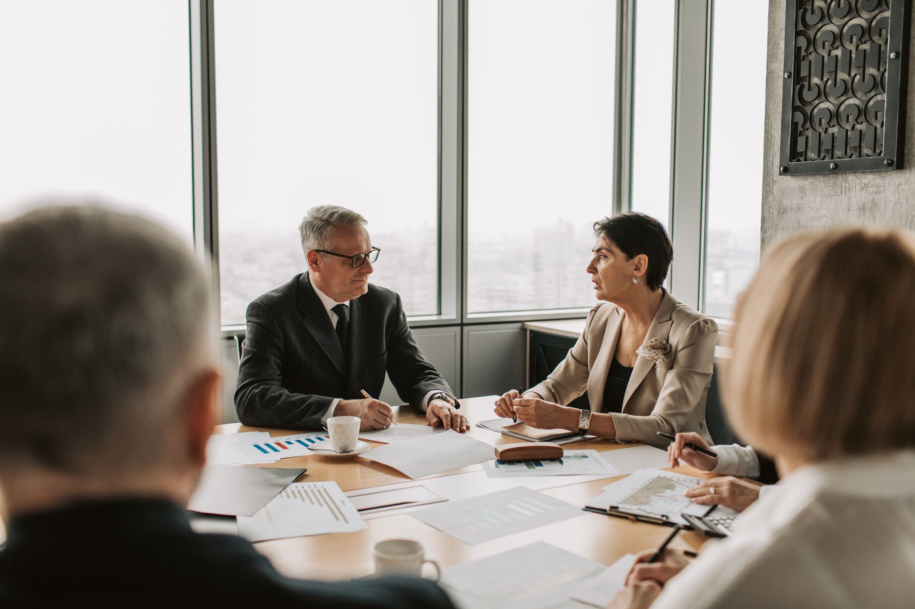 Business professionals engaged in a strategic meeting in a modern office setting with natu
